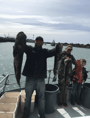 Fishermen holding catch on boat at sea