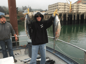 Man holding large fish on a boat deck