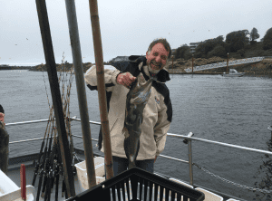 Man holding a fish on boat at sea