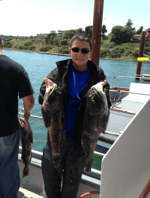 Man holding large fish on boat deck