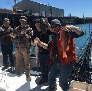 Group of friends showing their catch at a marina