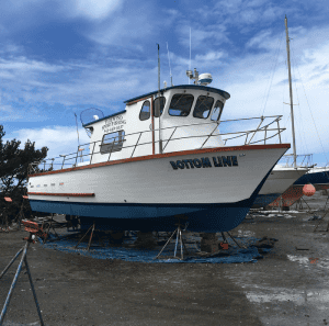 Fishing boat in dry dock under cloudy sky