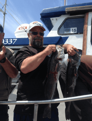 Man holding fish on boat sunny day