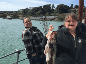 Two people enjoying a sunny day by waterfront