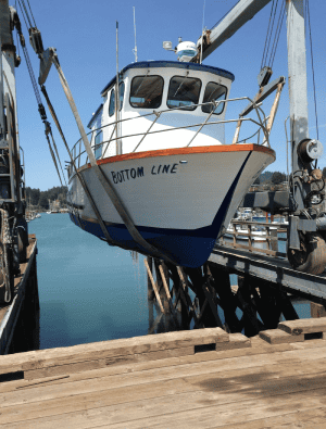 Fishing boat Bottom Line docked at sunny marina.