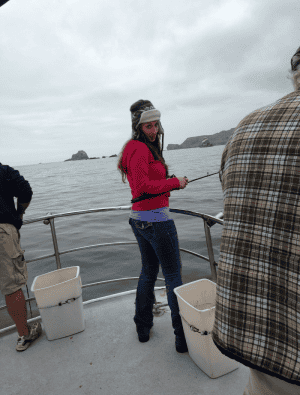 Woman fishing on boat with ocean background