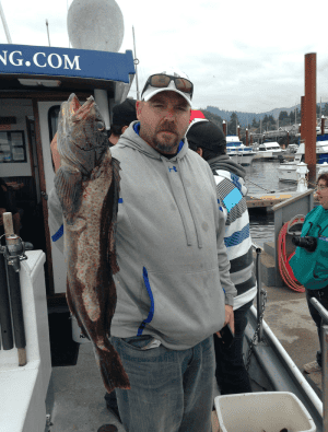 Man holding large fish at marina dock