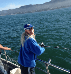 Woman fishing on boat sunny ocean background