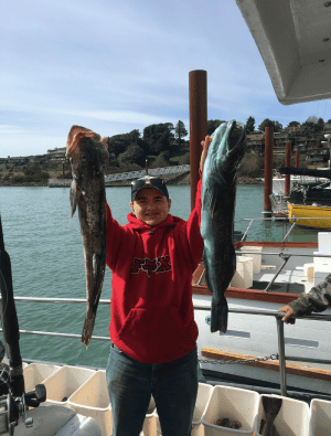 Angler with two large fish on a boat dock